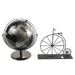 A vintage globe and a metal model of a penny farthing.