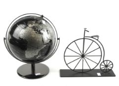 A vintage globe and a metal model of a penny farthing.