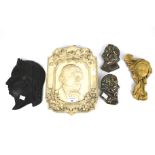 An assortment of ceramic and cast metal profiles of historic individuals.