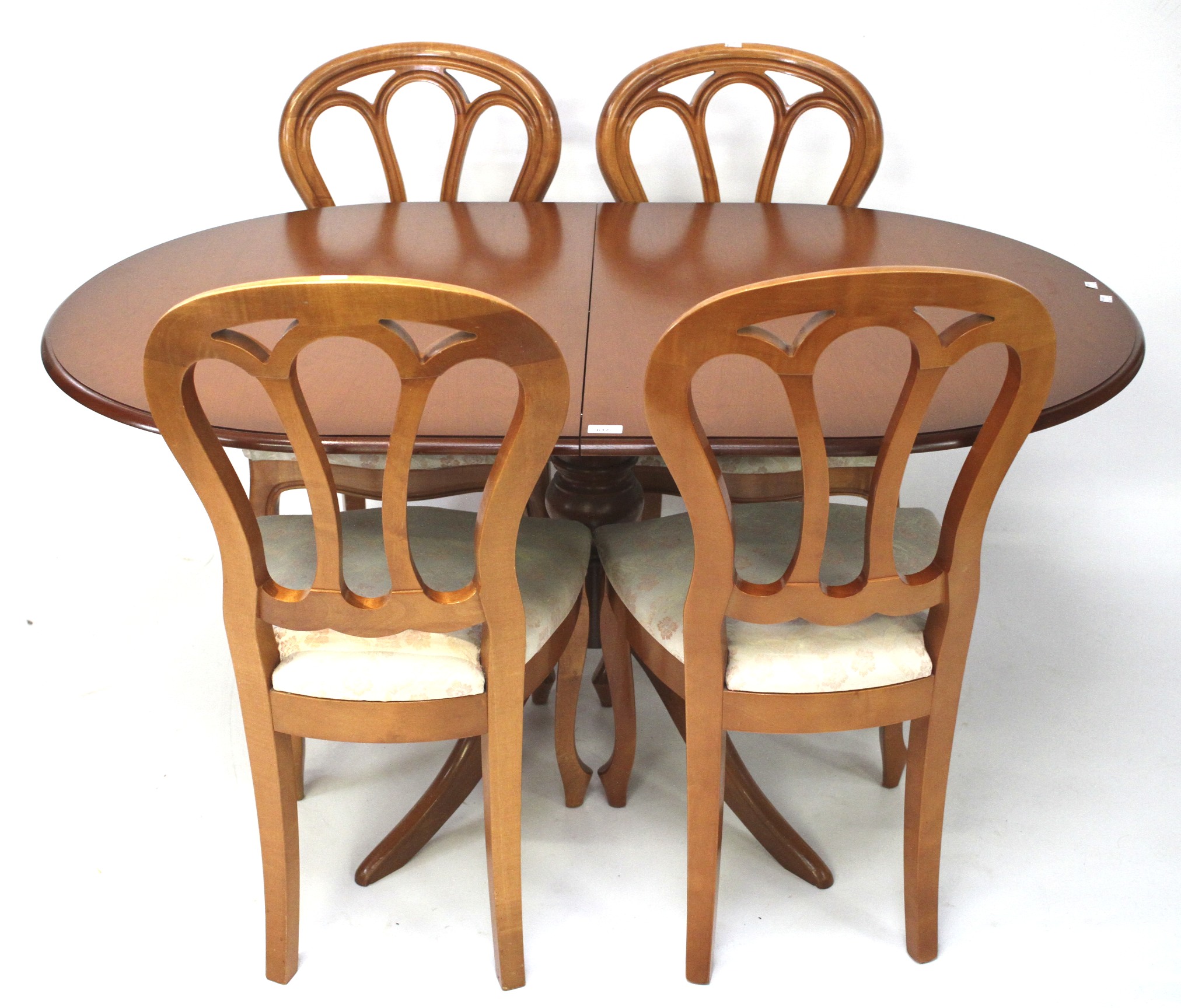 A contemporary wooden extendable dining table and four chairs.