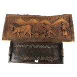 A carved wooden tray and wall plaque.