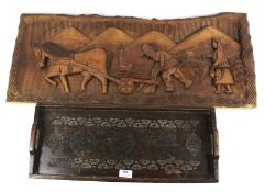 A carved wooden tray and wall plaque.