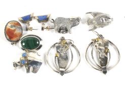 A collection of silver and white metal brooches.