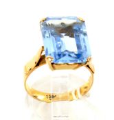 A yellow metal and rectangular pale blue synthetic single stone dress ring.
