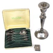A silver candlestick, silver vesta case and set of six silver plated spoons.