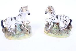 A pair of 19th century Staffordshire figures of Zebras.