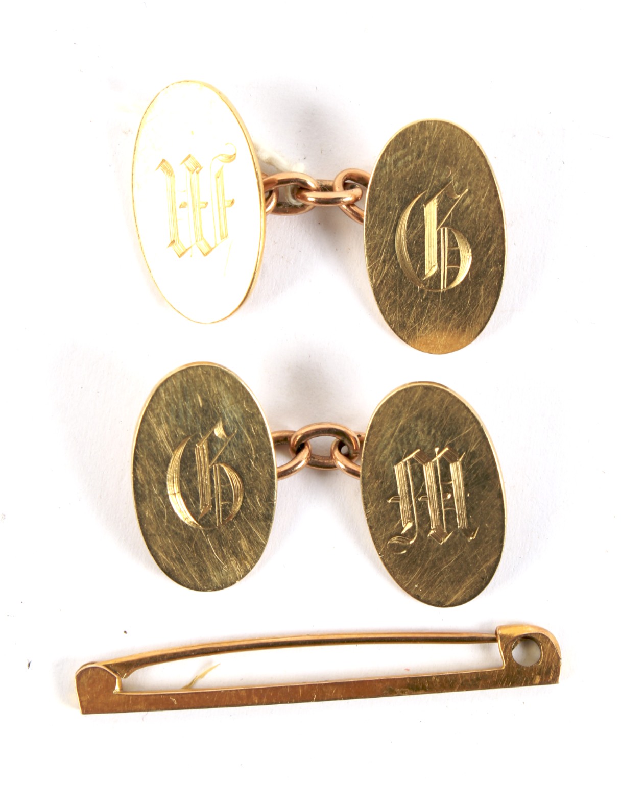 A pair of yellow metal cufflinks and a yellow metal bar brooch.