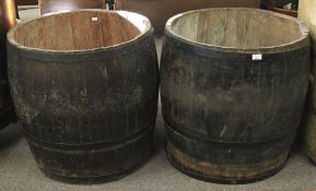 Two large coopered wooden barrels adapted into planters.