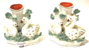 A pair of Staffordshire swan vases.
