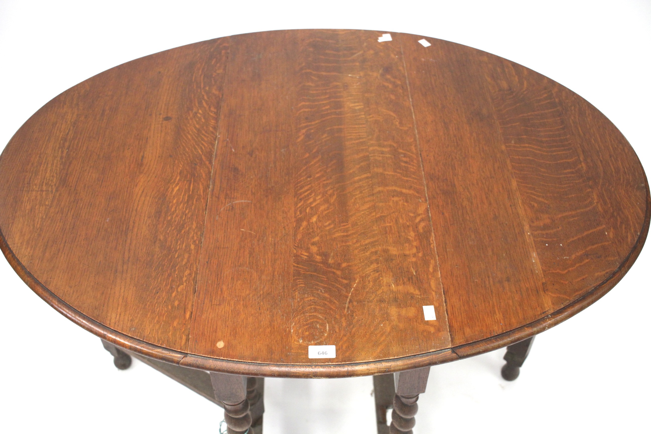 A 1930s oak oval toped gateleg table.