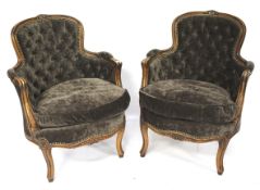 A pair of 20th century brown upholstered button back armchairs.