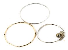 Three white metal bangles.