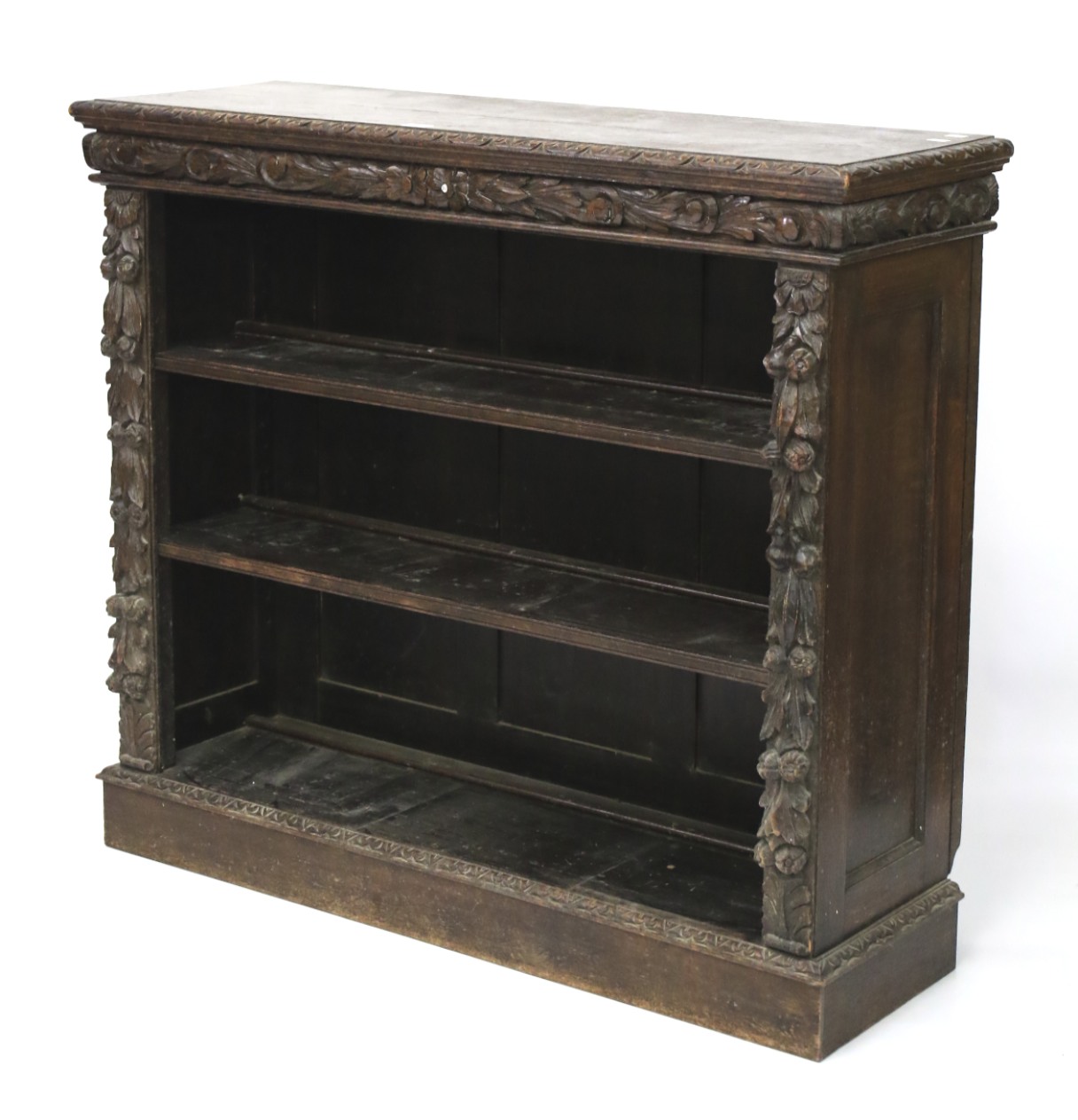 An early 20th century heavily carved oak Flemish style open bookcase.