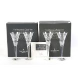 Two boxed pairs of Waterford crystal champagne flutes.