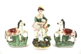 A Staffordshire figure of a woman and a pair of horses.