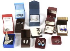 Twelve boxed pairs of silver and white metal earrings.