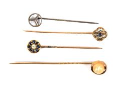 Four yellow and white metal tie pins.