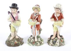 Three Staffordshire pearlware figures of Cupid in Disguise as street sellers, early 19th century.