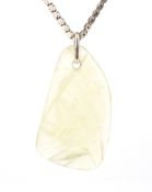 A Victorian gold chain hung with a later light-yellow jadeite pendant.