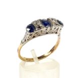 An early 20th century gold, sapphire and diamond carved half-hoop ring.