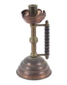 A late 19th century Arts and Crafts copper and brass candlestick.