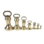 A set of seven graduated brass bell-shaped Parnall & Sons (Bristol) weights.
