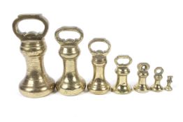 A set of seven graduated brass bell-shaped Parnall & Sons (Bristol) weights.