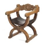 A carved armorial curule chair.