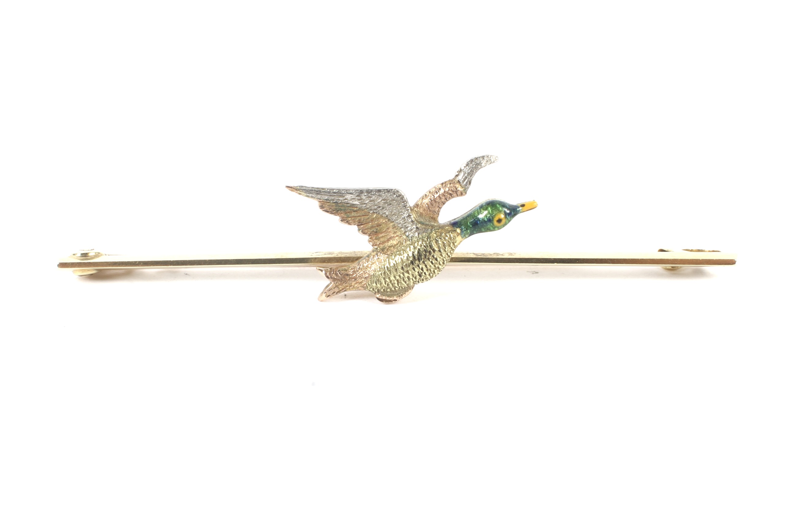 An early 20th century 15ct gold and platinum bar brooch adorned with a duck in flight.