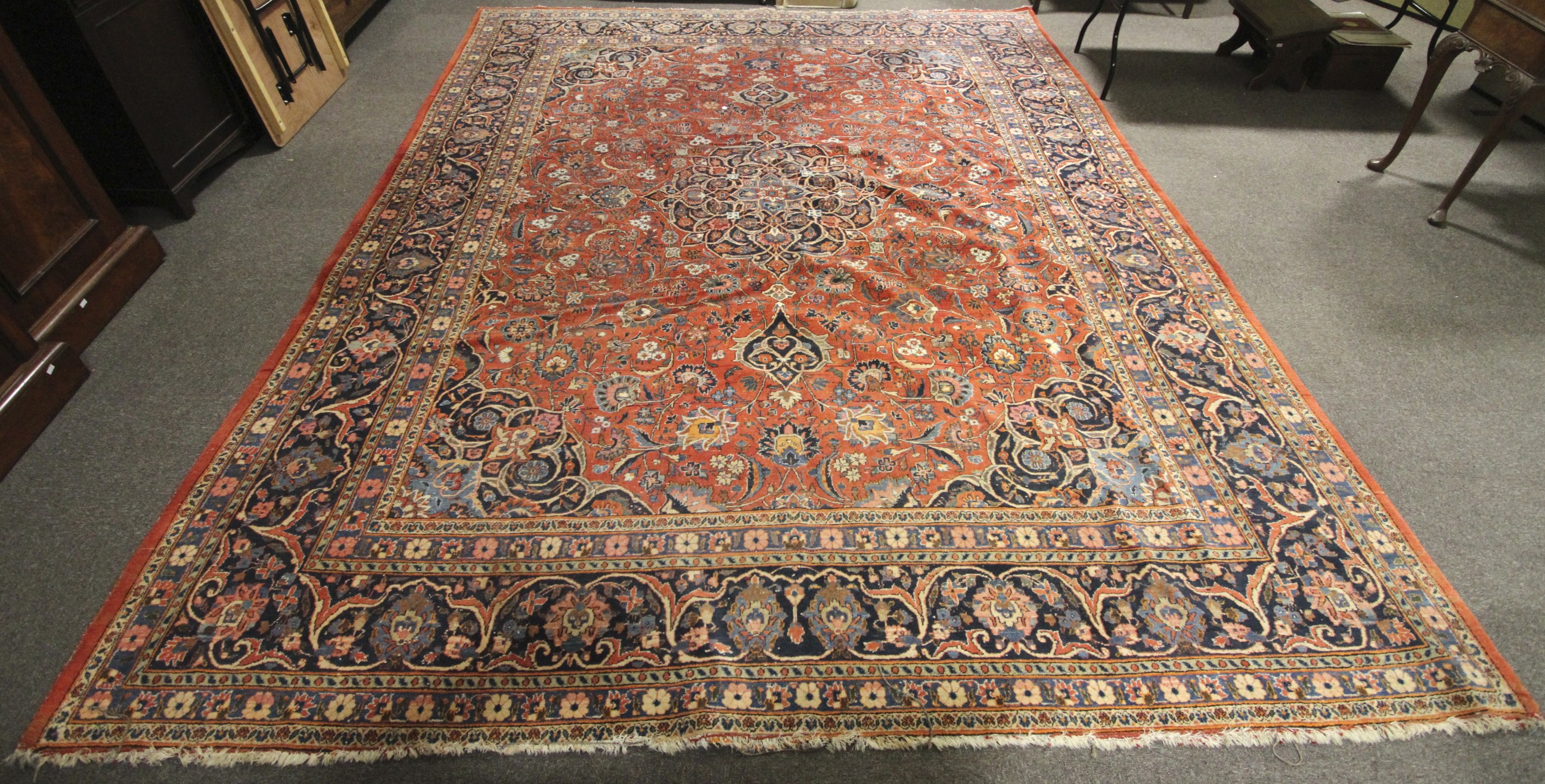 A large Persian style woollen carpet.