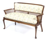 A 20th century bergère canework and upholstered salon sofa.