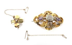 An early Victorian gold, aquamarine and amethyst three stone brooch and a four-leaf clover brooch.