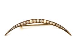 A late Victorian gold and half-pearl open crescent brooch.