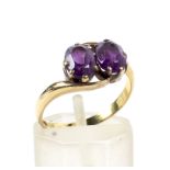 An early 20th century gold and amethyst two-stone cross-over ring.