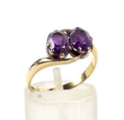 An early 20th century gold and amethyst two-stone cross-over ring.