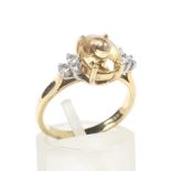 A yellow topaz dress ring. The centre stone flanked by six diamonds.