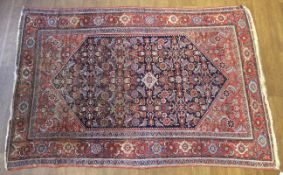 A Persian style woollen ground rug.