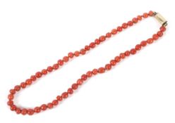 An early 20th century red coral slightly barrel shaped bead necklace.