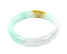 A Chinese light-green mottled hardstone bangle, probably jadeite.