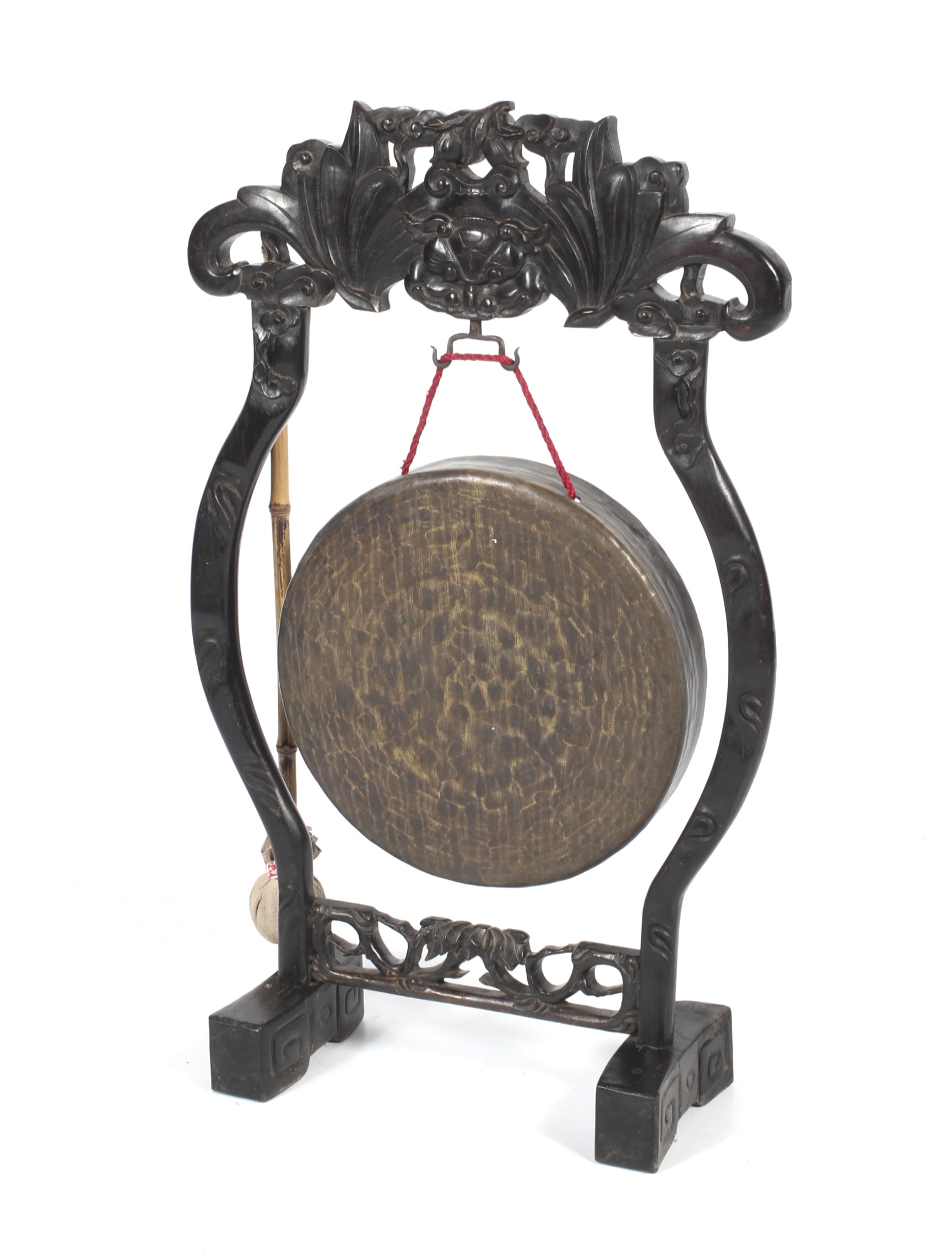 A Chinese gong raised on a carved ebonised stand.