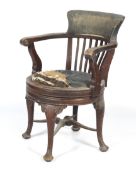 An Edwardian stained oak swivel captain's chair.