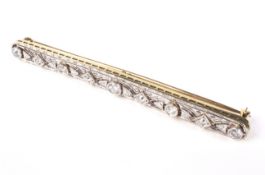 A mid-20th century gold and diamond bar brooch in Art Deco style.