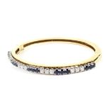 A Continental sapphire and diamond half-hoop hinged bangle.