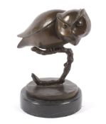 A 20th century bronze sculpture of an owl on a black marbled circular base.