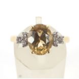 A yellow topaz dress ring. The centre stone flanked by six diamonds.