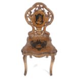 A late 19th century Black Forest carved marquetry and penwork musical chair.