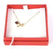 A 9ct gold chain and garnet heart pendant. Weight 2.1g.