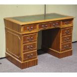 A yew reproduction leather-topped knee hole pedestal desk.
