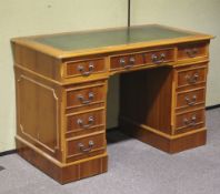 A yew reproduction leather-topped knee hole pedestal desk.