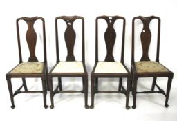 A set of four high backed oak chairs.